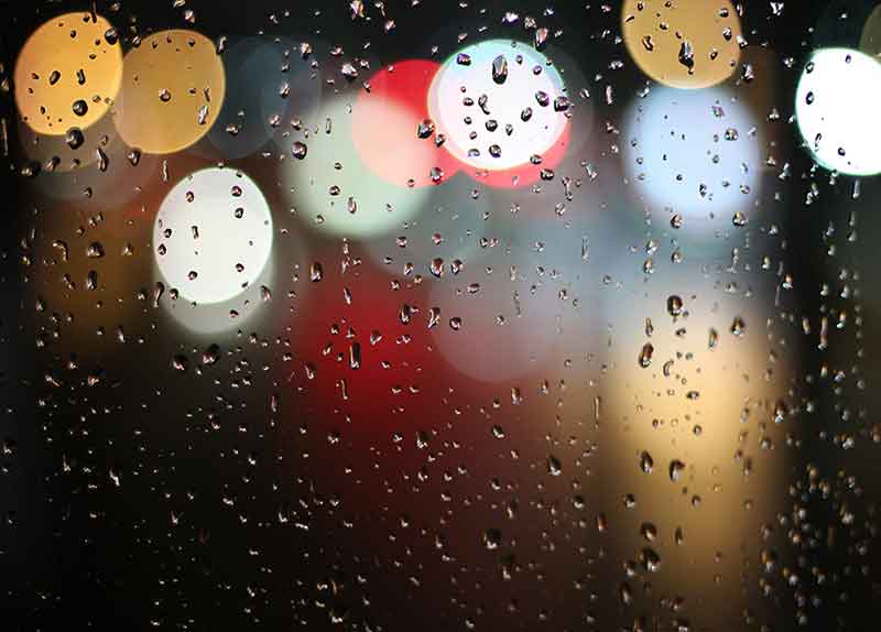 raindrops on window | looking out to road lights at night